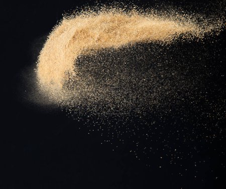 Photo for Sand flying explosion, Golden sand wave explode. Abstract sands cloud fly. Yellow colored sand splash throwing in Air. Black background Isolated high speed shutter, throwing freeze stop motion - Royalty Free Image