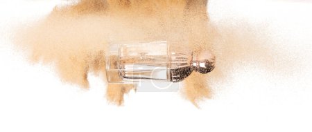 Téléchargez les photos : Perfume bottle product Sand flying explosion, lotion serum bottle sands grain wave explode. Abstract cloud fly. Perfume cosmetic advertising sea sand splash throwing in Air. White background Isolated - en image libre de droit