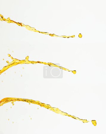 Photo for Orange, lemon juice or oil lubricant splash, liquid gold yellow drink drops. Fruit beverage water elements in line form . Fresh splashing and flowing jets, white background isolated freeze motion - Royalty Free Image