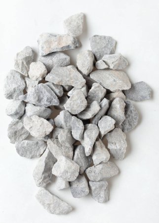 Téléchargez les photos : Pile de pierre de gravier de construction se trouvent dans le groupe, gravier de roche grise montrent de près la texture et la poussière, la conception de l'objet. Fond blanc isolé tir au gel - en image libre de droit