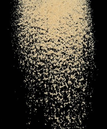 Foto de Brown Sugar explosión voladora, azúcar de grano marrón explotan mosca nube abstracta. Hermosa semilla completa salpicadura de caña de azúcar en el aire, diseño de objetos alimenticios. Congelación de enfoque selectivo tiro Fondo negro aislado - Imagen libre de derechos