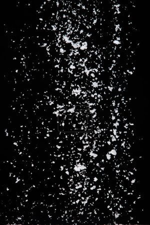 Photo for Photo image of falling down snow, heavy big small size snows. Freeze shot on black background isolated overlay. Fluffy White snowflakes splash cloud in mid air. Real Snow high speed shutter - Royalty Free Image