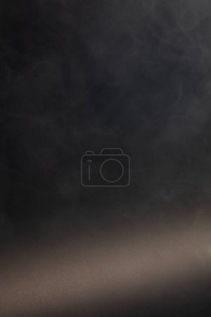 Téléchargez les photos : Bouffées denses de fumée blanche et de brouillard sur fond noir, nuages de fumée abstraits, mouvement flou. Fumeurs soufflant de la machine mouche de glace sèche flottant dans l'air, texture effet - en image libre de droit