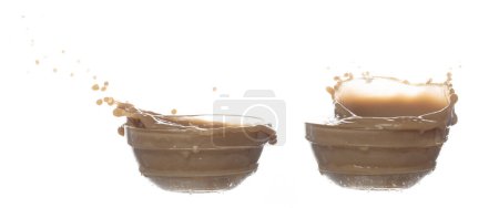 Téléchargez les photos : Chute de thé de lait versant vers le bas dans la ligne de forme. Lait Café glacé éclaboussure goutte goutte de goutte de verre, chocolat attaque de cacao flottant explosion dans l'air. Fond blanc isolé, stop motion - en image libre de droit