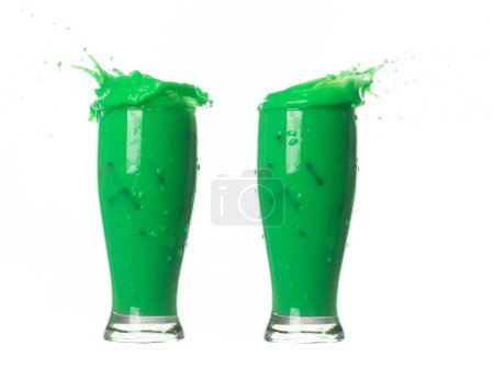 Téléchargez les photos : Matcha vert thé au lait verser tomber, explosion dans l'air. Matcha vert lait thé éclaboussure en forme de bol en verre comme couleur de peinture. fond blanc isolé haute vitesse obturateur gel mouvement - en image libre de droit