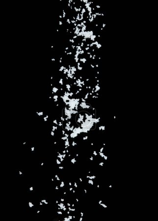 Téléchargez les photos : Explosion volante de sel, les sels de grains blancs de cristal explosent la mouche nuageuse abstraite. Belle éclaboussure complète de sel de graines dans l'air, conception d'objets alimentaires. Mise au point sélective gel plan fond noir isolé - en image libre de droit