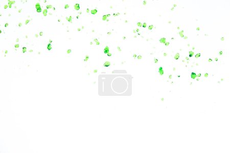 Téléchargez les photos : Beaucoup de gouttelettes Dot de jus vert de la nature éclaboussent dans l'air. Feuille verte de l'eau verser du ciel et purifier propre naturel. De nombreuses formes d'éclaboussures d'eau coulent sur fond blanc Isolé - en image libre de droit