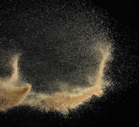 Photo for Sand flying explosion, Golden sand wave explode. Abstract sands cloud fly. Yellow colored sand splash throwing in Air. black background Isolated high speed shutter, throwing freeze stop motion - Royalty Free Image
