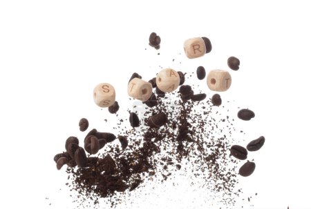 Foto de Rico aroma granos de café recién tostados vuelan en el aire como la danza junto con letras alfabeto bloques de perlas de juguete "START", que encarna la esencia de la semilla de café en polvo. Fondo blanco explosión aislada - Imagen libre de derechos