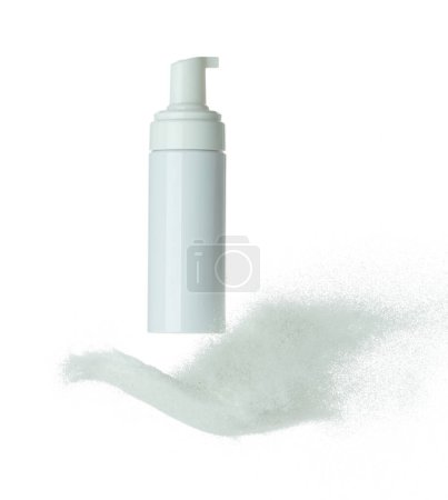 Foto de Recipiente cosmético mosca botella blanca salpicaduras en la arena blanca. Tubo de polvo de arena transparente en medio del aire. Crema de loción hidratante explosión botella volando. Fondo blanco aislado obturador de alta velocidad - Imagen libre de derechos