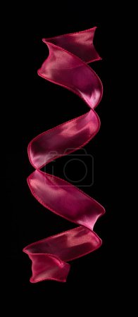 Photo for Red rose ribbon long straight fly in air with curve roll shiny. Red yellow ribbon for present gift birthday party to wrap around decorate, curl curve long straight. Black background isolated - Royalty Free Image
