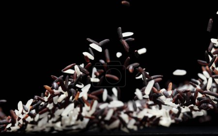 Foto de Explosión voladora japonesa de Riceberry, mosca abstracta de la caída de la baya del arroz blanco. Hermosa semilla completa de jazmín salpicadura de arándano en el aire, objeto de comida. Fondo negro aislado enfoque selectivo borroso - Imagen libre de derechos