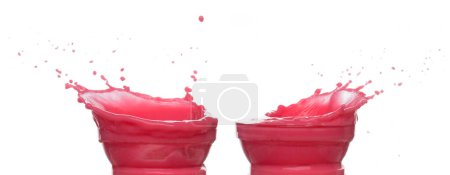Téléchargez les photos : Le jus de fraise de tomate rouge éclabousse dans un bol en verre, la vague de sang rouge tombe dans l'air. L'explosion colorée au vin rouge s'est répandue. Fond blanc Obturateur haute vitesse isolé, mouvement de gel - en image libre de droit