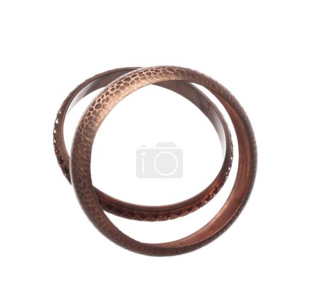 Photo for Fashion india copper bangle bracelet with beautiful work detail is value. Luxury indian copper metal bangle bracelet is fashion trend and fly in air. White background isolated - Royalty Free Image