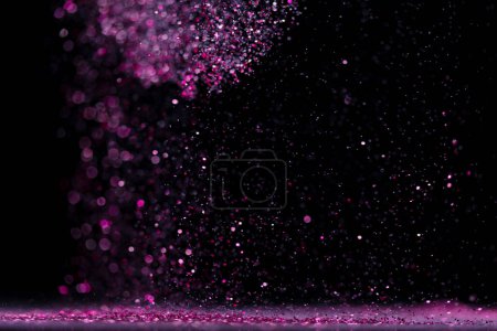 Photo for Explosion metallic pink glitter sparkle. Choky Glitter powder spark blink celebrate, blur foil explode in air, fly throw pink glitters particle. Black background isolated, selective focus Blur bokeh - Royalty Free Image
