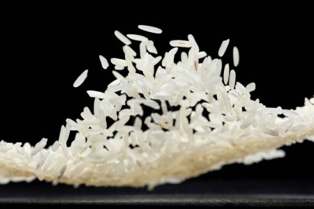 Photo for Japanese Rice flying explosion, white grain rices fall abstract fly. Beautiful complete seed jasmine rice splash in air, food object design. Black background isolated selective focus blur - Royalty Free Image