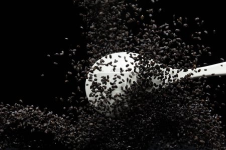 Photo for Black Sesame seeds flying explosion, black grain wave floating. Abstract cloud fly splash in air. Sesame seed is material food.  Black background Isolated selective focus blur - Royalty Free Image