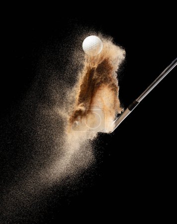 Photo for Golf ball tee explode from sand bunker. Golfer hit ball with club to sand explosion to green. Golf club hit ball tee in sand wedge bunker explosion. Black background isolated freeze motion - Royalty Free Image
