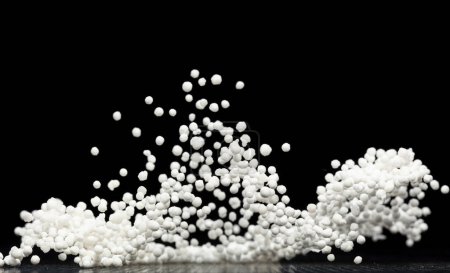 Photo for Sago seeds falling down from measure cup, white grain wave floating, Abstract fly splash in air. White Sago seeds is material food. Black background isolated selective focus blur - Royalty Free Image