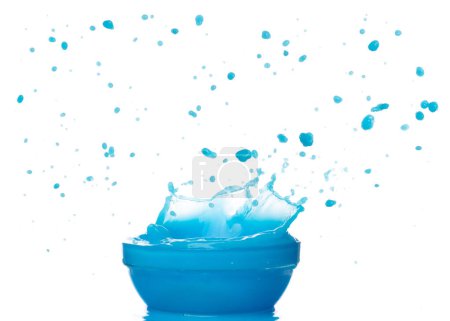 Photo for Blue paint water spill splash in bowl cup. Blue liquid lotion moisturizer cosmetic pour float in mid air. Blue cocktail drink explosion throw fluttering. White background isolated high speed shutter - Royalty Free Image