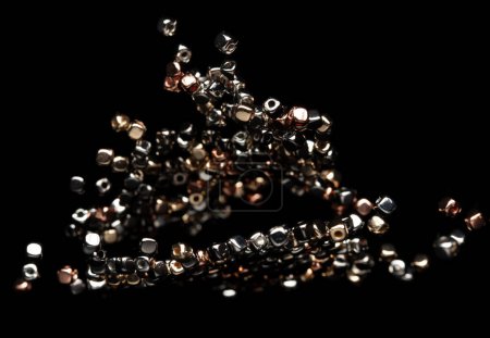 Téléchargez les photos : Mode Silver cube de perles d'or avec de beaux détails de travail est la valeur. Luxe argent cuivre métal perle sequin est tendance de la mode et voler dans l'air. Fond noir isolé foyer sélectif flou - en image libre de droit