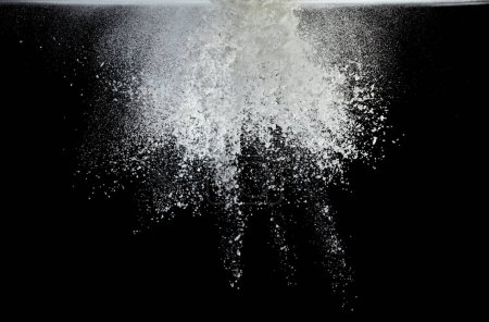 Foto de Explosión de mosca de harina de almidón de tapioca, polvo blanco almidón de tapioca caer en el aire. El polvo de harina condimentada es material de elemento. Maquillaje de sombra de ojos. Fondo negro Desenfoque selectivo aislado - Imagen libre de derechos