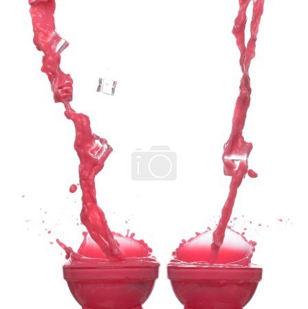 Téléchargez les photos : Le jus de fraise de tomate rouge éclabousse dans un bol en verre, la vague de sang rouge tombe dans l'air. L'explosion colorée au vin rouge s'est répandue. Fond blanc Isolé série deux d'images - en image libre de droit
