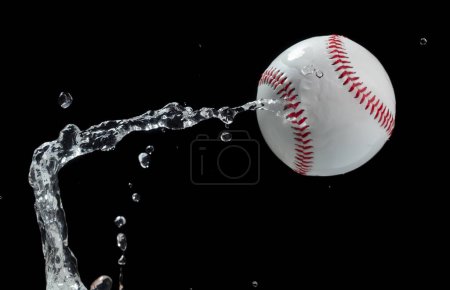 Téléchargez les photos : Balle de baseball a frappé l'eau et éclabousser dans l'air. Balle de baseball voler sous la pluie et éclaboussures éclaboussures dans l'eau gouttelette. Fond noir Isolé série deux d'images - en image libre de droit