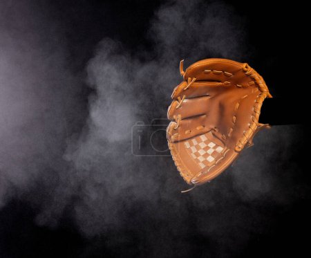 Photo for Leather glove mitt receive hit baseball ball and dust soil explode in air. Baseball ball throw and hit to center of mitt glove. Black background isolated freeze action - Royalty Free Image