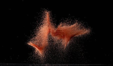 Photo for Red Sand flying explosion, particle dot grain wave explode. Abstract cloud fly. orange dried soil colored sand splash throwing in Air. Black background Isolated - Royalty Free Image
