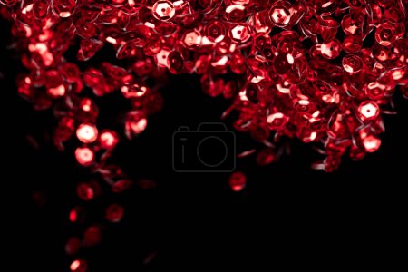 Téléchargez les photos : Explosion paillettes rouges métalliques paillettes scintillement. Étincelle de paillettes rouges scintillement célébrer, feuille floue exploser dans l'air, mouche jeter particule rouge. Fond noir isolé, foyer sélectif Bokeh Flou - en image libre de droit