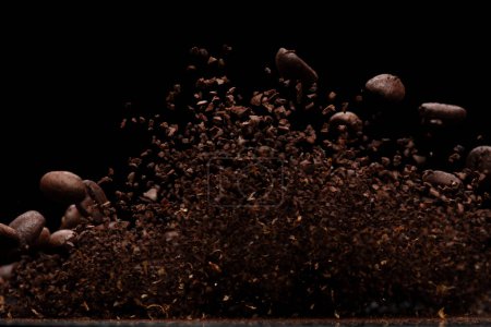 Foto de Explosión de la mosca del polvo del café, flotador molido café vertiendo, ola como olor a humo. Salpicadura de polvo molido de café lanzando en el aire. Fondo negro Desenfoque selectivo aislado - Imagen libre de derechos