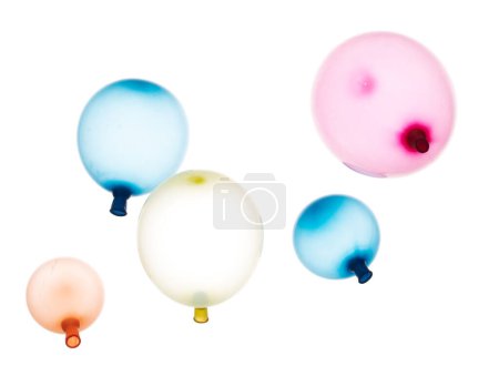 Foto de Globos inflados de goma de colores vuelan en el aire. Muchos globos inflados coloridos en rojo, azul, dispersión de tiro amarillo. Juguete para niños para jugar en la fiesta de cumpleaños y celebrar, fondo blanco aislado - Imagen libre de derechos