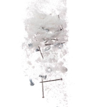 Foto de Clavo espiga Tornillos de tuerca objeto afilado bajo la nieve en el camino. Objeto peligroso afilar clavos de vidrio escondido en la nieve. Caída de nieve con riesgo de accidente cubierta de basura residuos de basura. Fondo blanco aislado - Imagen libre de derechos
