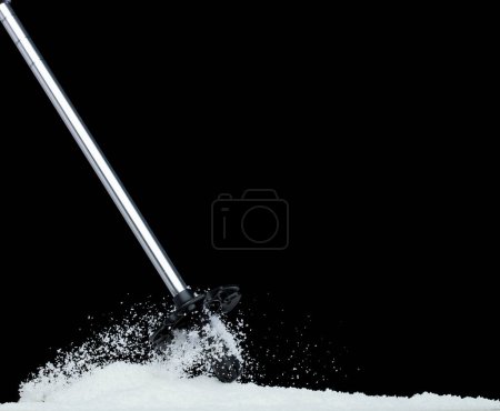 Photo for Trekking Poles put on snow ice. Telescopic trekking poles stick device for elderly people to walk with support protection hiking snow base in woods mountain. Black background isolated - Royalty Free Image