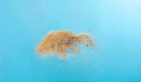 Photo for Big size Sand flying scatter, Golden grain wave explode. Abstract cloud fly. Yellow colored sand splash throwing in Air. Blue sky background Isolated, throwing freeze stop motion - Royalty Free Image