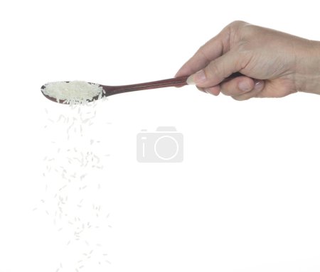 Foto de Caída de arroz japonés, los arroces de grano blanco vertiendo nubes abstractas vuelan desde la cuchara. Hermoso arroz de semilla completa en el aire, diseño de objetos alimenticios. Congelación de enfoque selectivo plano fondo blanco aislado - Imagen libre de derechos