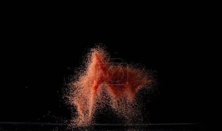 Téléchargez les photos : Explosion volante de sable rouge, onde de grains de particules explosent. Vol nuageux abstrait. sol séché orange éclaboussures de sable coloré jetant dans l'air. Fond noir Isolé - en image libre de droit