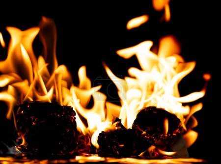 Foto de Llamas de fuego El fuego arde sobre un fondo negro aislado. Encendiendo llamas sobre la textura abstracta del papel. Fuego quemar en papel a las cenizas y crear llama. Foto real de alta resolución - Imagen libre de derechos
