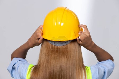 Photo for Female worker blonde hair lost her fingers from injured accident in industrial job. Woman engineer wear yellow hard hat show her lost fingers from work and insurance. White background isolated - Royalty Free Image