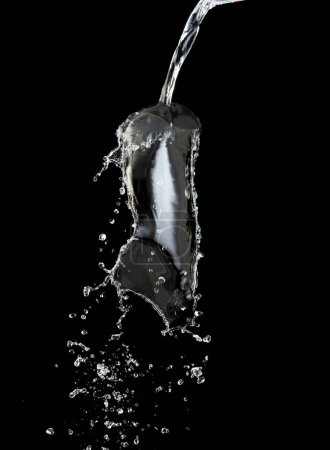 Photo for Pouring Water on pants object to create shape form splash fluttering in droplet and wave. Pouring water to object make curve drop splash in directions. Black background isolated - Royalty Free Image