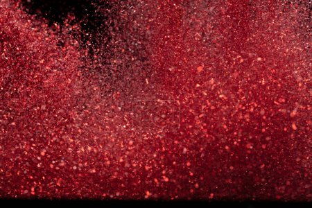 Photo for Explosion metallic red glitter sparkle. rose Glitter powder spark blink celebrate, blur foil explode in air, fly throw red glitters particle. Black background isolated, selective focus Blur bokeh - Royalty Free Image