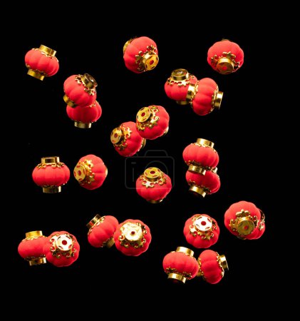 Téléchargez les photos : Beaucoup de lanterne chinoise rouge flottent dans l'air avec mouche élément or. Beaucoup de lampe de lanterne de Chine rouge obtiennent le souffle du vent suspendu et montrent beaucoup de vue d'angle. Articles décoratifs Nouvel An chinois. Fond noir isolé - en image libre de droit