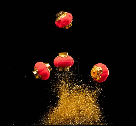 Foto de Gold Chinese Money lantern fly with dust particle in air. Chinese new year Yuanbao gold lantern floating to golden money sand particle. Language is wealthy prosperity. Black background isolated - Imagen libre de derechos
