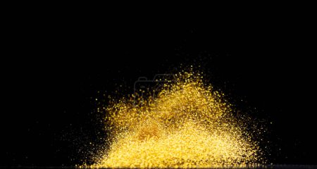 Foto de Explosión de brillo metálico dorado en el aire. Brillo de oro chispa de arena parpadear celebrar el año nuevo chino, volar lanzar partículas de brillo de oro. Fondo negro aislado, enfoque selectivo Blur bokeh - Imagen libre de derechos