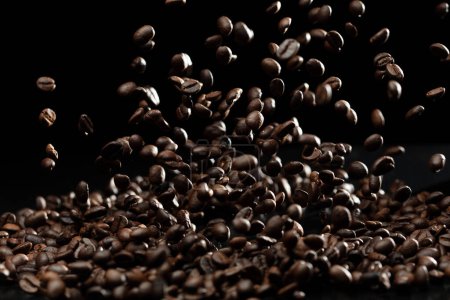 Foto de Coffee roasted bean fly explosion, Coffee crushed float pouring mix with beans. Roasted Coffee bean splash explosion in mid Air. Black background Isolated selective focus blur - Imagen libre de derechos