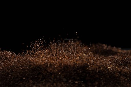 Téléchargez les photos : Ground Coffee roasted powder dust fly explosion, Coffee crushed ground float pouring. Roasted Coffee powder ground dust splash explosion in mid Air. Black background Isolated selective focus blur - en image libre de droit