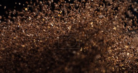 Foto de Ground Coffee roasted powder dust fly explosion, Coffee crushed ground float pouring. Roasted Coffee powder ground dust splash explosion in mid Air. Black background Isolated selective focus blur - Imagen libre de derechos