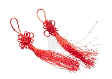 Foto de Dos borlas chinas rojas flotan en el aire con la mosca de la cola. Muchas borlas rojas de China consiguen el viento que sopla que cuelga y atan el hilo encima del desorden. Artículos decorativos chinos de Año Nuevo. Fondo blanco aislado - Imagen libre de derechos
