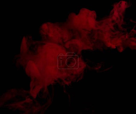 Téléchargez les photos : Bouffées de fumée blanche et de brouillard denses rouges sur fond noir, nuages de fumée abstraits, mouvement flou. Fumeurs soufflant de la machine mouche de glace sèche flottant dans l'air, texture effet - en image libre de droit